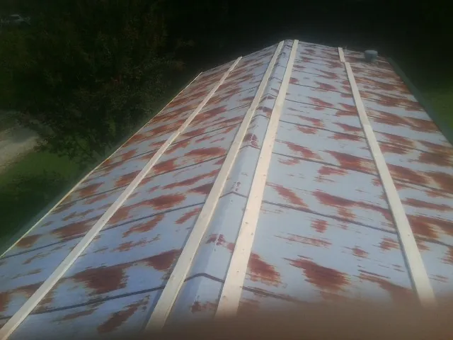Rusted metal roof panels with new wood purlins before replacement — Storm Damage Roof Repair in East Montpelier by Roofing Brothers