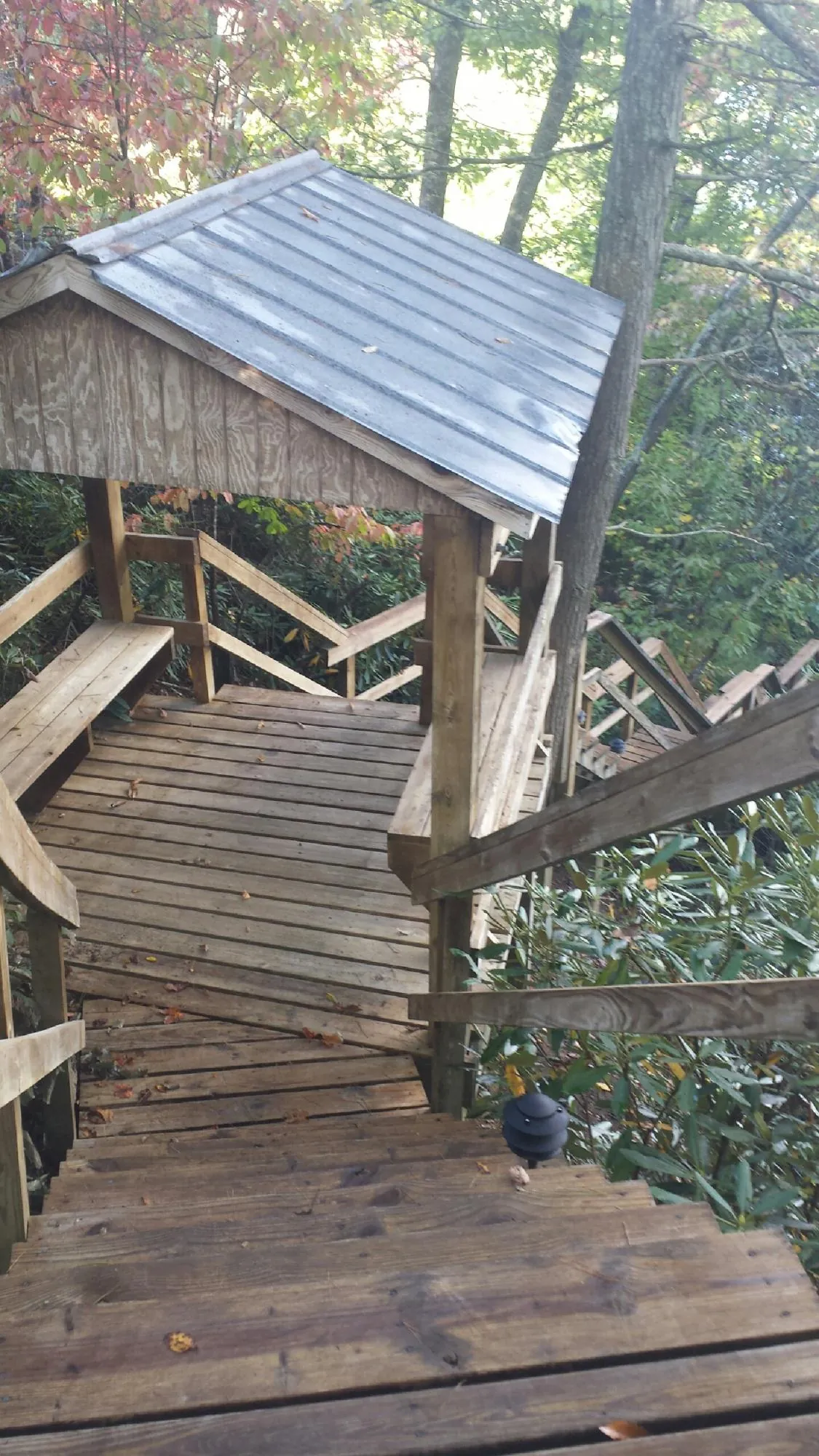 Metal roofed shelter over wooden steps on a wooded walkway — Skylight Repair & Installation work by our crew in East Montpelier