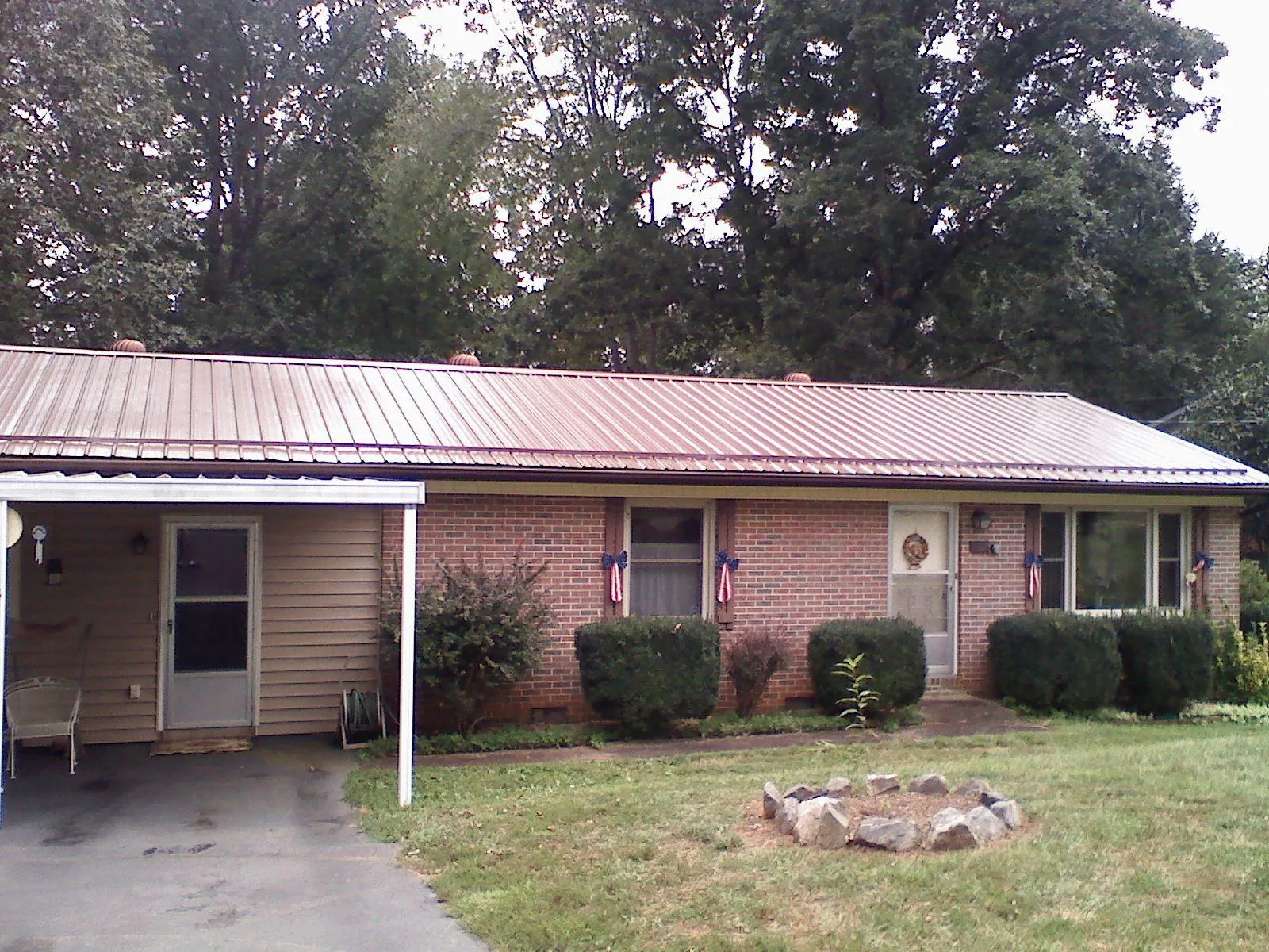 Bronze metal roof and carport on a brick ranch home — Roof Repair work by our crew in East Montpelier
