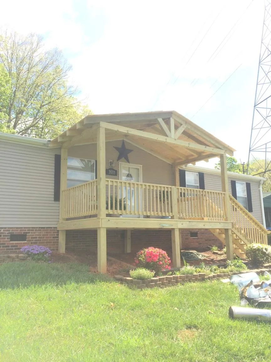 New gabled porch roof and deck railing added to a ranch home in East Montpelier